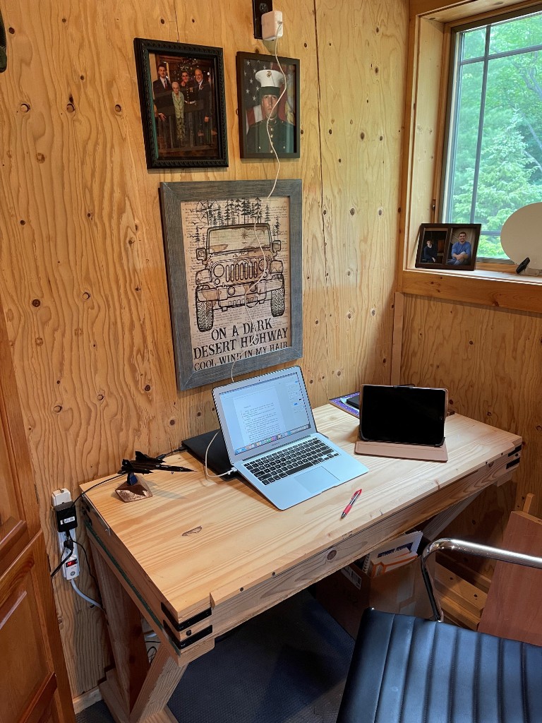 Bruce Meek's writing desk with laptop, tablet, and aviation model